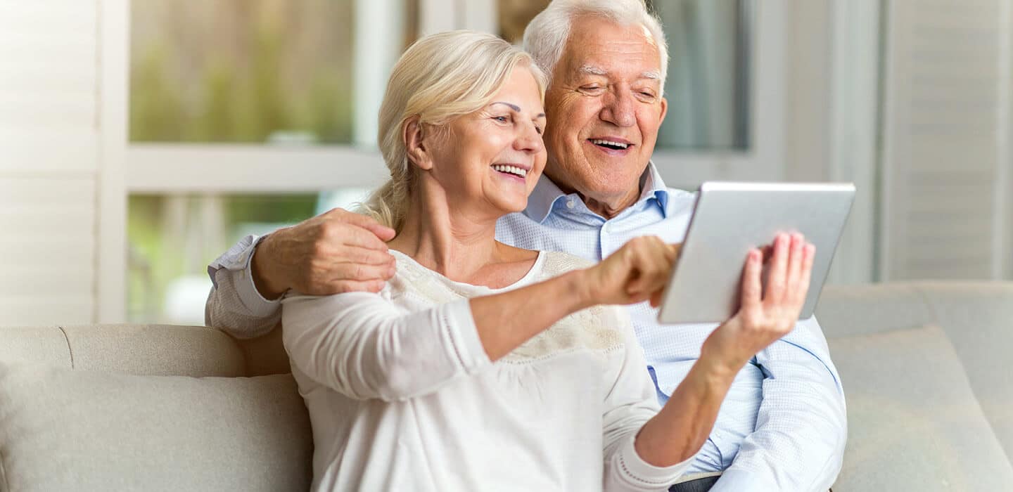 couple looking at a tablet and smiling