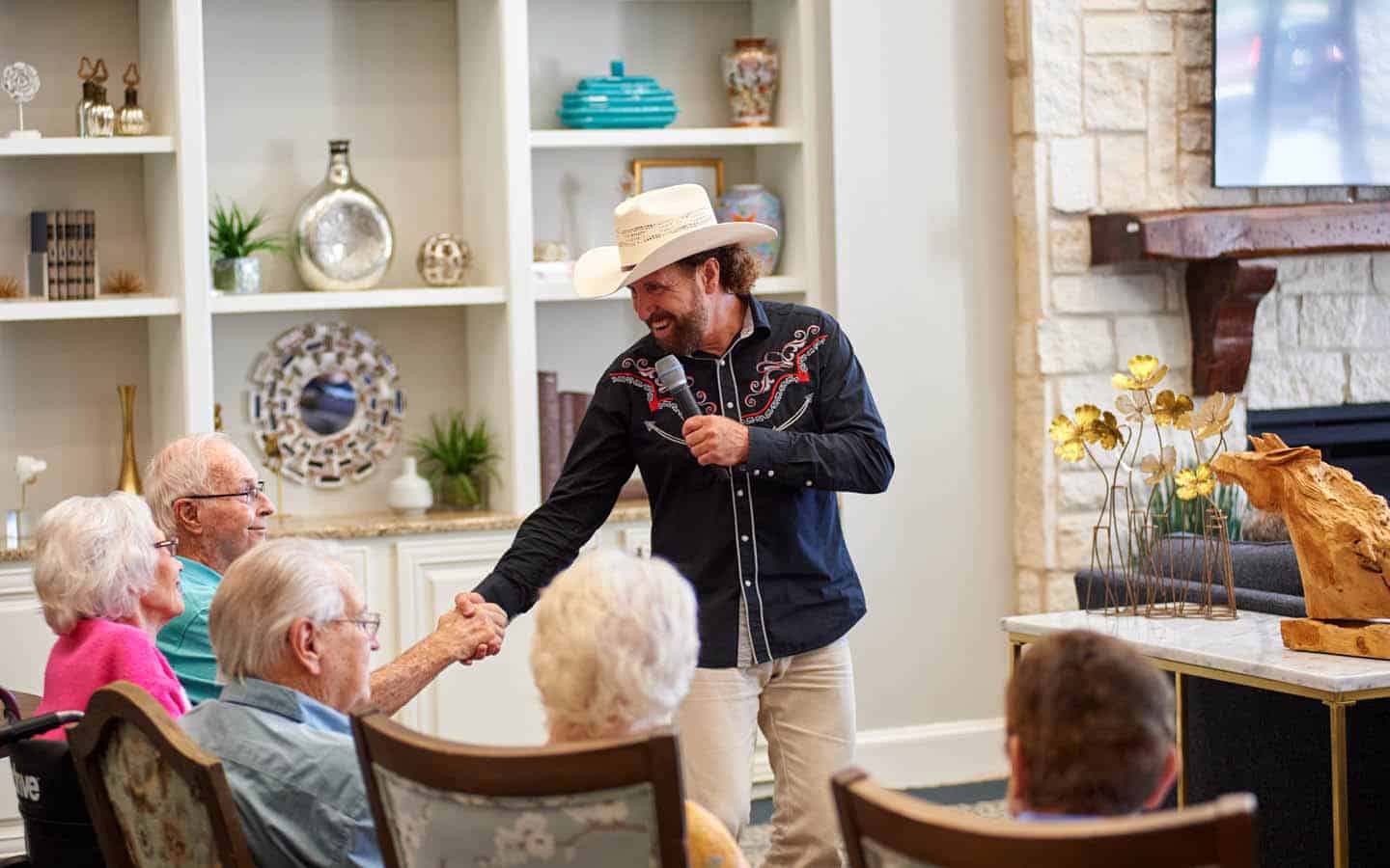 man in cowboy hat shaking a residents hand at an event in the lobby